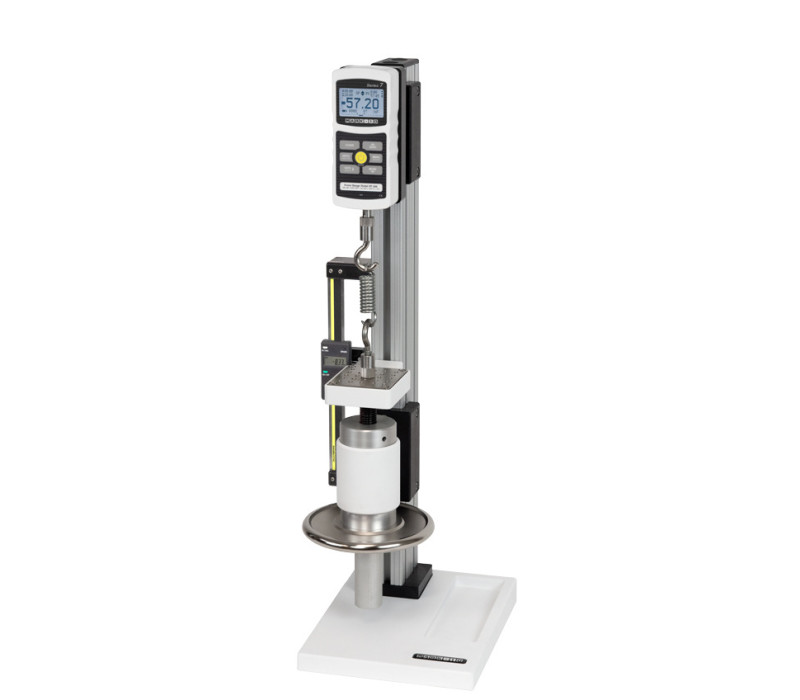 El banco de pruebas vertical TSC1000 se muestra en una aplicación de ensayo de muelles de tracción con un dinamómetro digital de la serie 7, un juego de ganchos y un indicador digital de recorrido opcional.