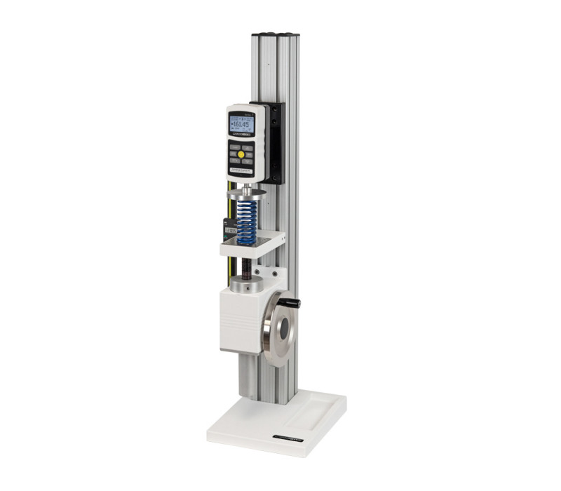 El banco de pruebas vertical TSF se muestra en una aplicación de ensayo de muelles de compresión con dinamómetro digital modelo M7-200, plato de compresión y pantalla digital de recorrido opcional.