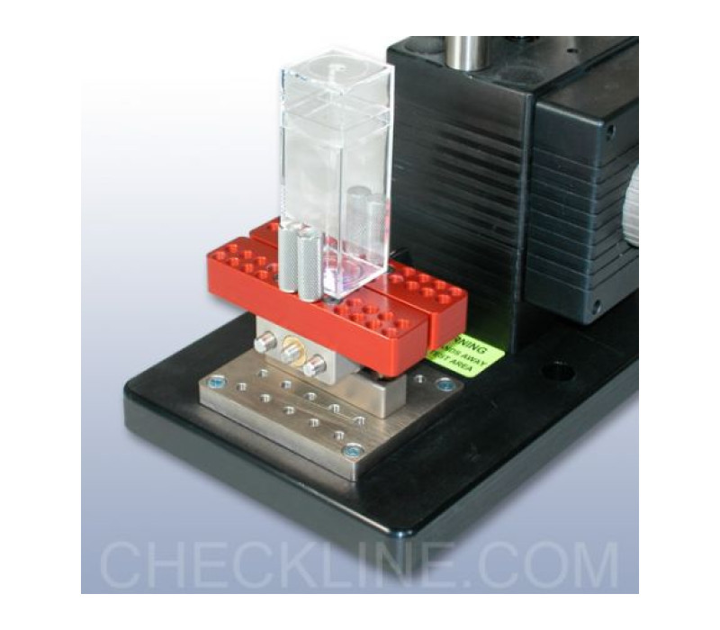G1058 se muestra asegurando un contenedor rectangular, montado en un banco de pruebas Mark-10 mediante el adaptador G1055.