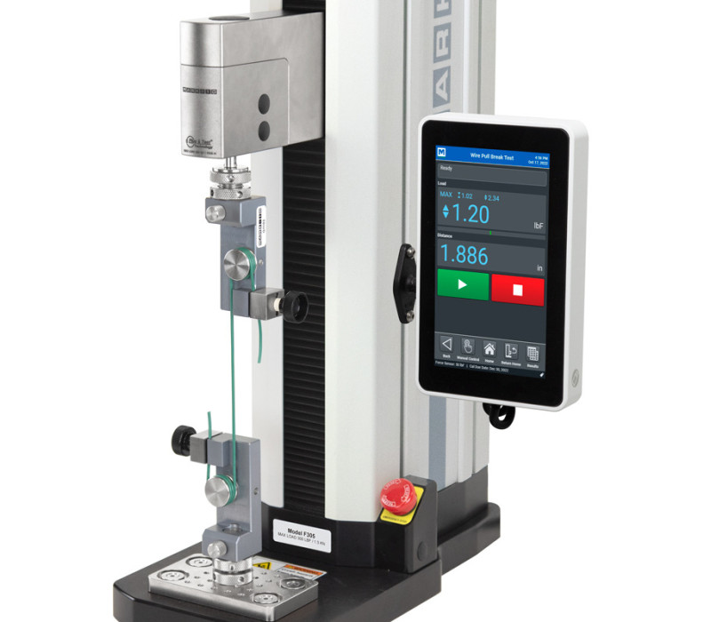 Se muestra un bastidor de pruebas F305-EM configurado para una prueba de tracción vertical de cables con dos pinzas para cables G1103.